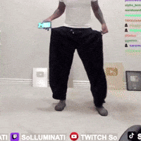 A Man In A White Shirt And Black Pants Is Holding A Cell Phone In His Hands GIF