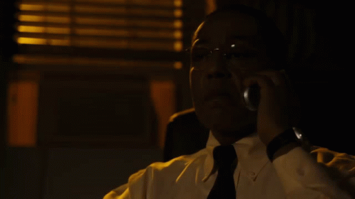 A Man In A White Shirt And Black Tie Talks On A Cell Phone GIF