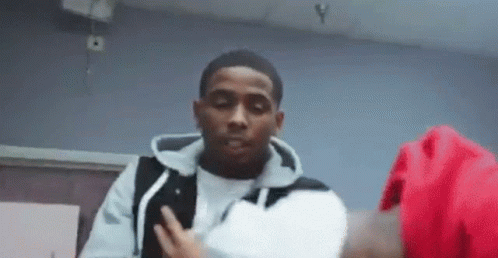 A Man In A White Shirt And Black Vest Is Standing Next To A Woman In A Red Jacket . GIF