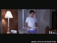 A Man In A White Shirt And Blue Shorts Is Holding A Hula Hoop In A Room .. GIF
