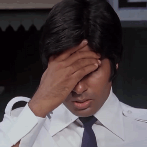 A Man In A White Shirt And Blue Tie Covers His Face With His Hand GIF