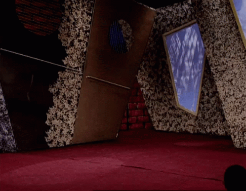 A Man In A White Shirt And Red Pants Is Jumping In The Air In A Room GIF