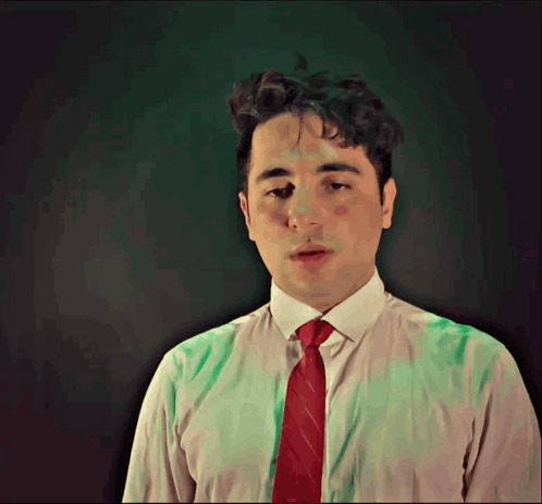 A Man In A White Shirt And Red Tie Is Looking Down GIF