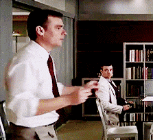 A Man In A White Shirt And Red Tie Stands In A Room GIF