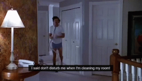 A Man In A White Shirt And Shorts Is Cleaning His Room GIF