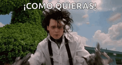 A Man In A White Shirt And Suspenders Is Holding A Pair Of Scissors In His Hand . GIF