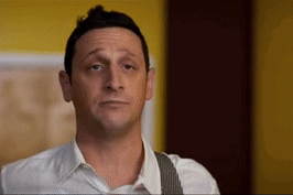 A Man In A White Shirt And Suspenders Is Making A Face GIF