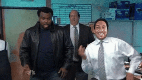 A Man In A White Shirt And Tie Is Dancing In An Office While Two Men In Suits Are Standing Behind Him . GIF
