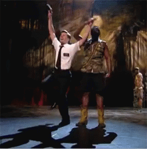 A Man In A White Shirt And Tie Is Dancing With A Man In A Kilt GIF