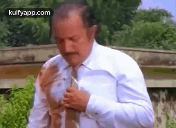 A Man In A White Shirt And Tie Is Getting Ready To Go Out . GIF