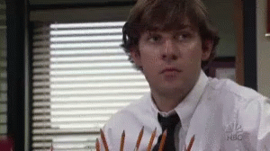 A Man In A White Shirt And Tie Is Holding A Bunch Of Pencils In His Hands . GIF