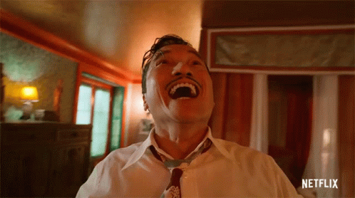 A Man In A White Shirt And Tie Is Laughing With The Netflix Logo In The Corner GIF