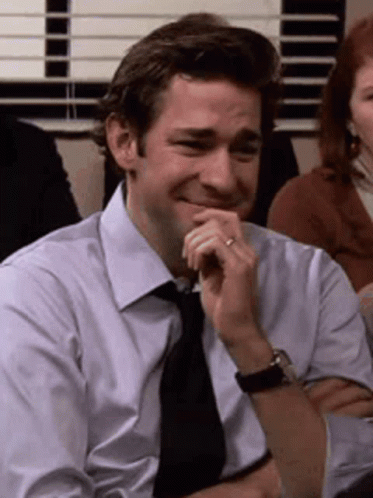 A Man In A White Shirt And Tie Is Smiling With His Hand On His Chin . GIF