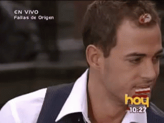 A Man In A White Shirt And Vest Is Eating A Candy Bar On A Television Screen That Says Hoy GIF