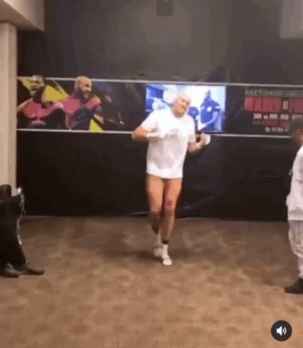 A Man In A White Shirt And White Socks Is Jumping Rope In A Gym GIF