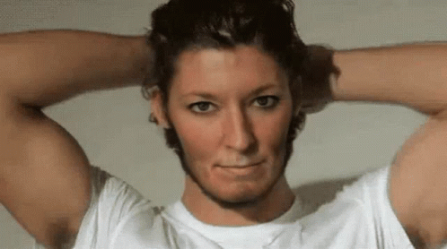 A Man In A White Shirt Has His Hands On His Head GIF