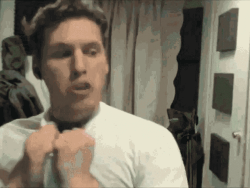 A Man In A White Shirt Is Adjusting His Bow Tie GIF