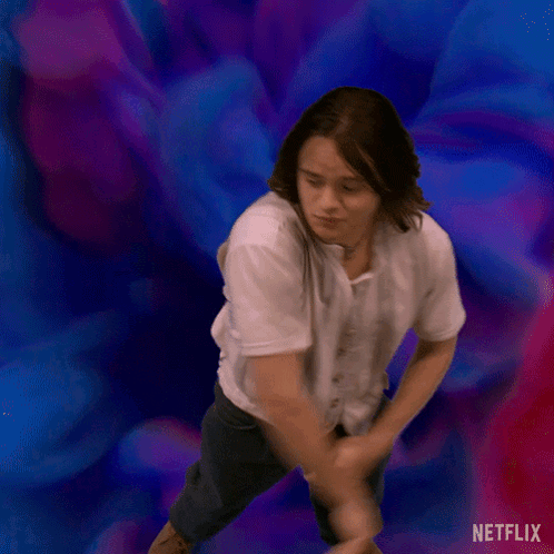 A Man In A White Shirt Is Dancing In Front Of A Blue And Purple Background . GIF