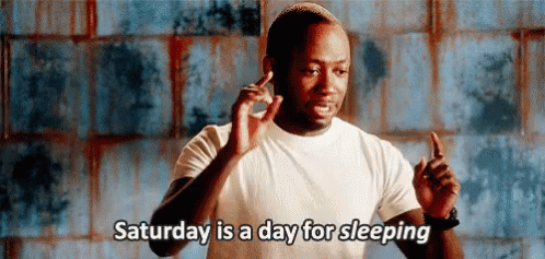 A Man In A White Shirt Is Giving A Thumbs Up And Saying `` Saturday Is A Day For Sleeping '' . GIF