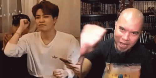A Man In A White Shirt Is Holding A Cell Phone Next To A Man In A Black Shirt GIF