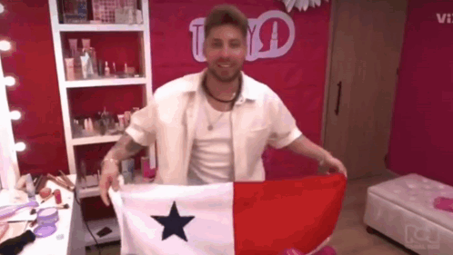 a man in a white shirt is holding a flag with a blue star on it