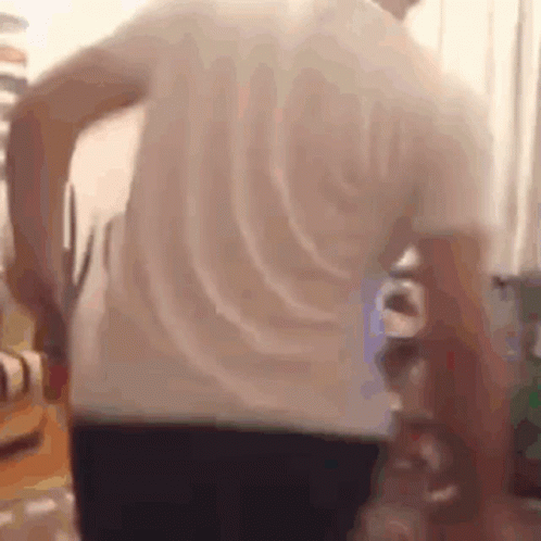 A Man In A White Shirt Is Holding A Pair Of Scissors In His Hand . GIF