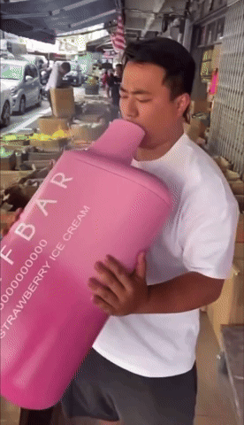 a man in a white shirt is holding a pink container that says strawberry ice cream