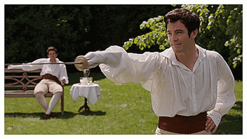 A Man In A White Shirt Is Holding A Sword In Front Of Another Man Sitting On A Bench GIF