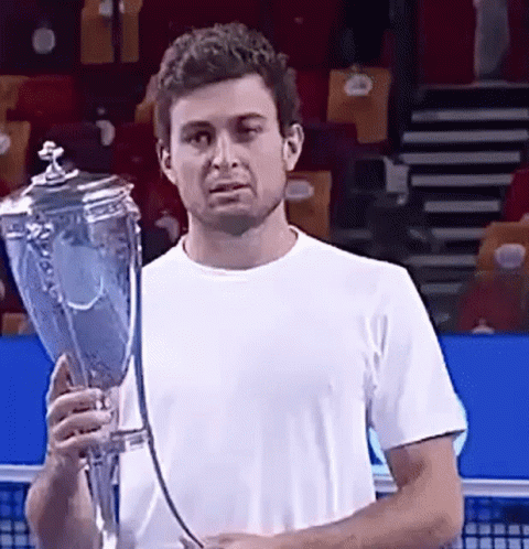 A Man In A White Shirt Is Holding A Trophy GIF