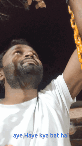A Man In A White Shirt Is Holding A Yellow Chain And The Caption Aye Haye Kya Bat Hai GIF