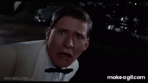 A Man In A White Shirt Is Holding His Fist Up And Says Why You Lucky Son Of GIF