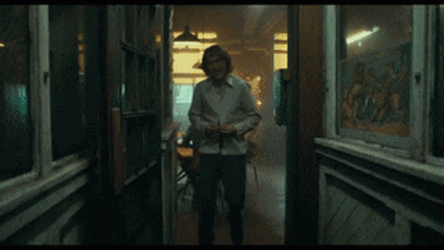 Man In White Shirt Laughing In Front Of Window GIF