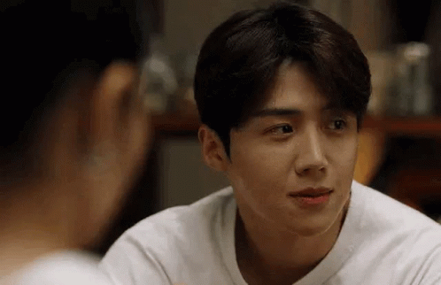 A Man In A White Shirt Is Looking At A Woman In A Mirror . GIF