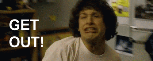 a man in a white shirt is making a face and says get out