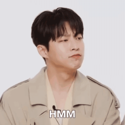 A Man In A White Shirt Is Making A Funny Face And The Word Hmm Is On The Bottom GIF