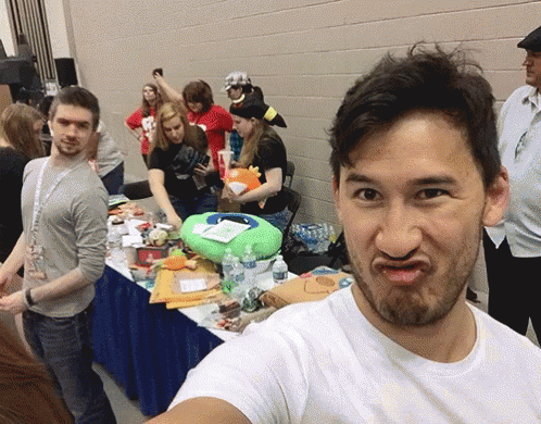A Man In A White Shirt Is Making A Funny Face In Front Of A Crowd GIF