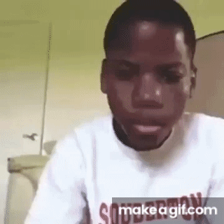 A Man In A White Shirt Is Making A Funny Face While Looking At The Camera . GIF
