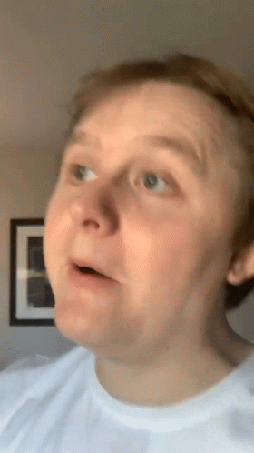 A Man In A White Shirt Is Making A Funny Face With His Mouth Open GIF