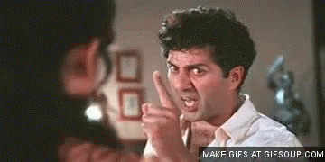 A Man In A White Shirt Is Pointing At Another Man With His Finger . GIF