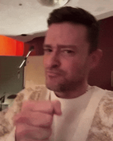 A Man In A White Shirt Is Pointing At The Camera With His Finger GIF