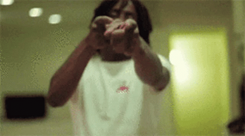 A Man In A White Shirt Is Pointing At The Camera With His Hands GIF