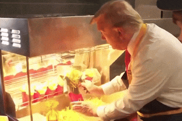 A Man In A White Shirt Is Preparing French Fries In A Display Case GIF
