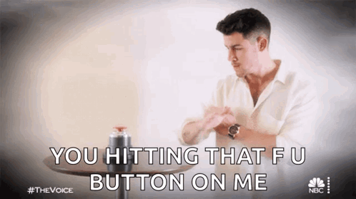 A Man In A White Shirt Is Sitting At A Table And Saying You Hitting That Fu Button On Me GIF