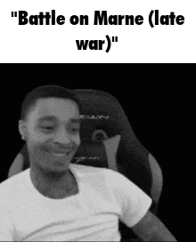 A Man In A White Shirt Is Sitting In A Chair And Smiling . GIF