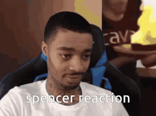 A Man In A White Shirt Is Sitting In A Chair With The Words Spencer Reaction Below Him GIF