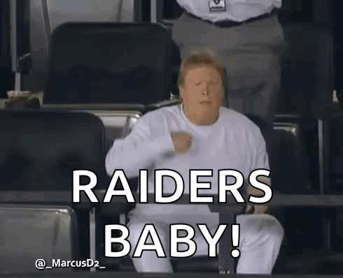 A Man In A White Shirt Is Sitting In A Stadium And Says " Raiders Baby " . GIF