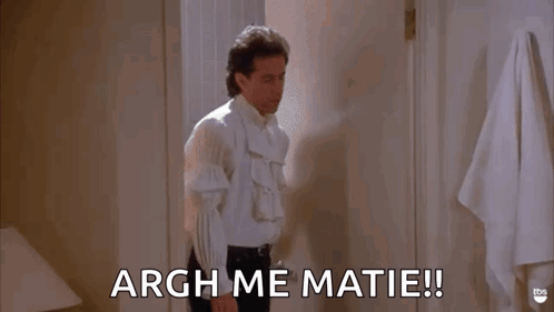 A Man In A White Shirt Is Standing In A Bathroom And Saying Argh Me Matie ! GIF