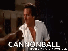 A Man In A White Shirt Is Standing In A Dark Room With A Cannonball Gif . GIF