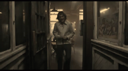 Man In White Shirt Smiling In Hallway GIF