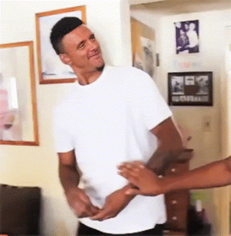 A Man In A White Shirt Is Standing In A Living Room With A Woman Holding His Hand GIF